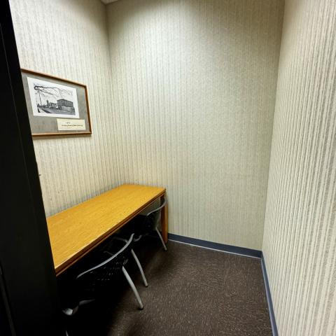 Room with desk and 2 chairs.  Historical picture on wall.